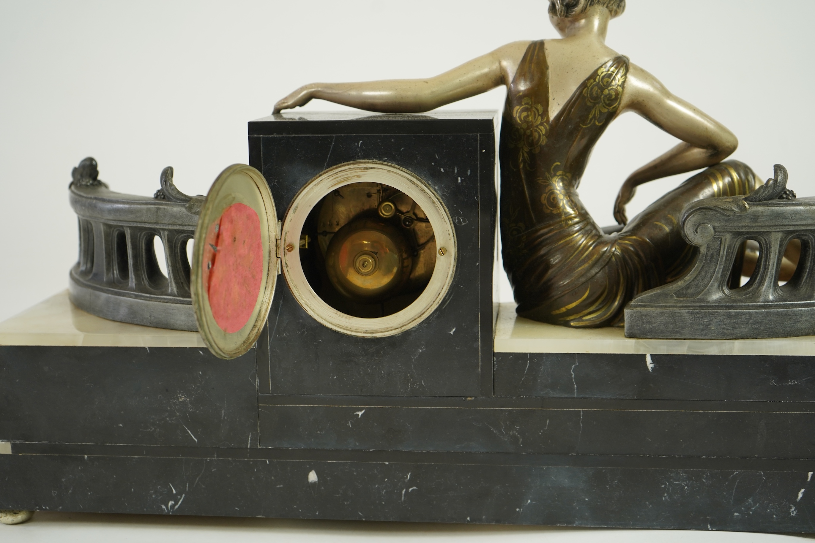 A French Art Deco onyx and patinated spelter clock surmounted with a lady and a black panther on a staircase